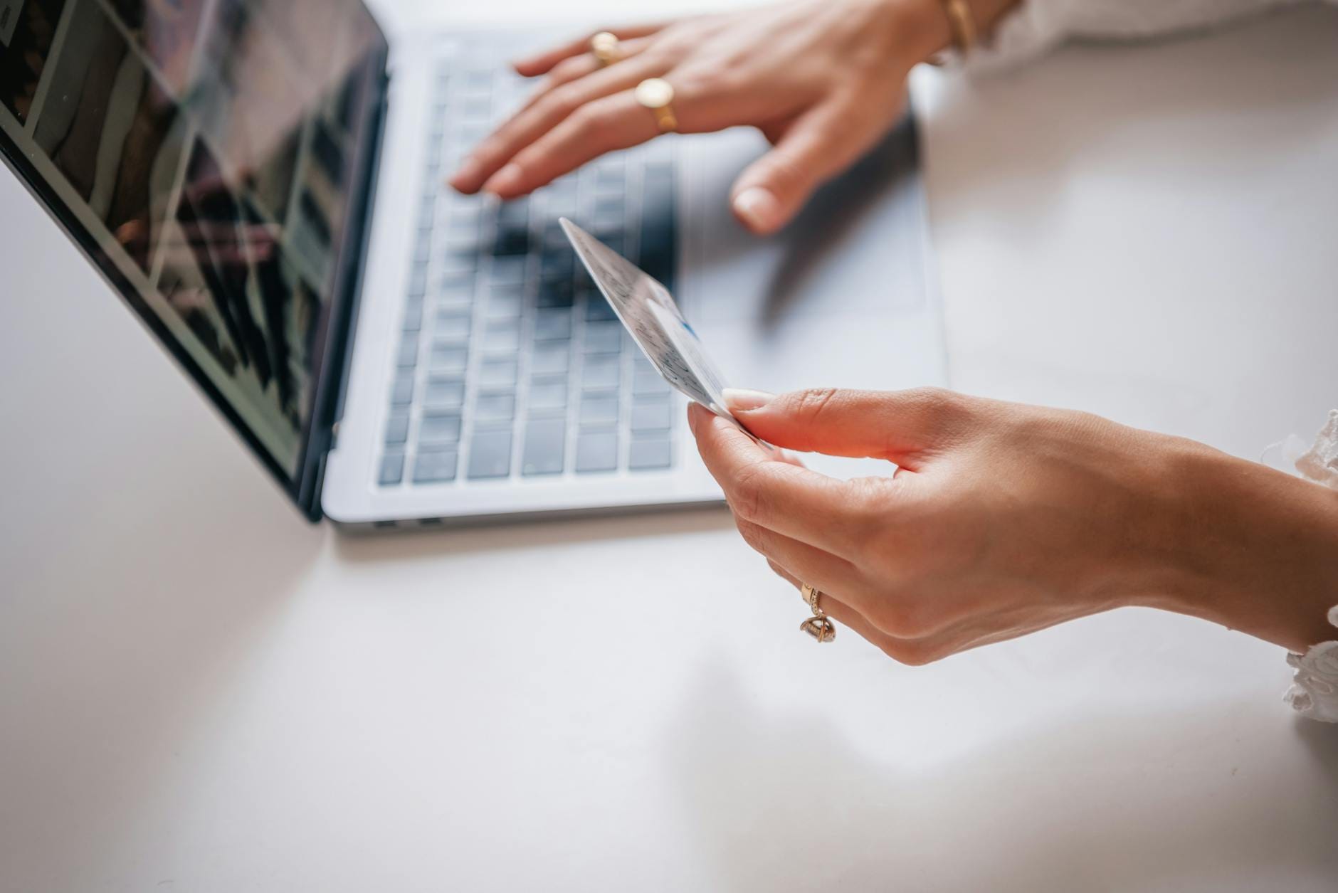 Kobieta z kartą kredytową robi zakupy online na laptopie